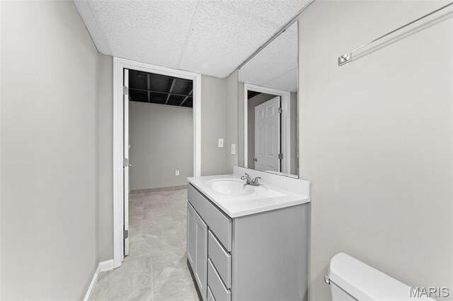 2713 Chapel View Dr, Florissant, MO 63031 - bathroom featuring vanity, toilet, a paneled ceiling, baseboards, and tile patterned flooring
