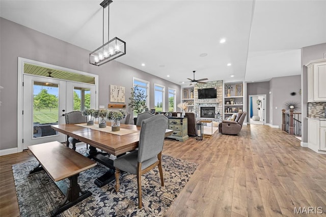 111 Foristell Ridge Ct, Foristell, MO 63348 - dining room featuring ceiling fan, light wood-style floors, a fireplace, french doors, and built in shelves