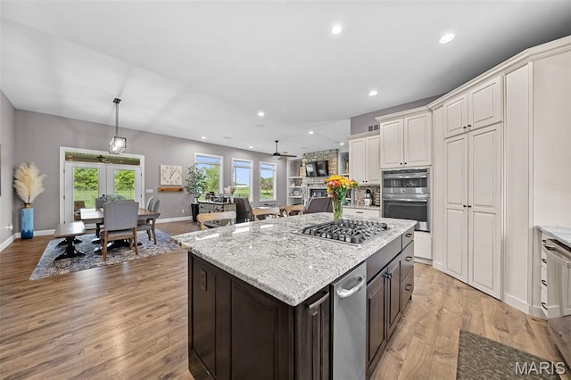 111 Foristell Ridge Ct, Foristell, MO 63348 - kitchen featuring stainless steel appliances, light wood-style floors, white cabinets, light stone countertops, and recessed lighting
