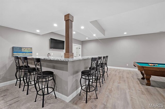 111 Foristell Ridge Ct, Foristell, MO 63348 - kitchen with baseboards, a breakfast bar, light stone countertops, light wood-style floors, and pool table