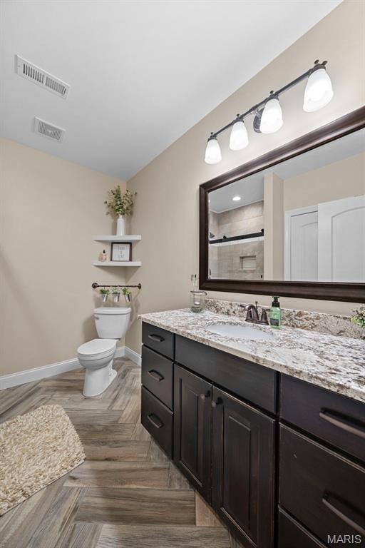 111 Foristell Ridge Ct, Foristell, MO 63348 - full bathroom featuring toilet, vanity, a tile shower, and baseboards