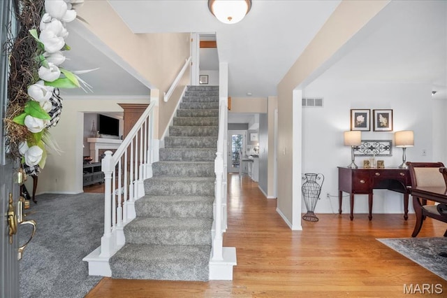 300 Wildberry Ln, Saint Charles, MO 63304 - foyer featuring stairway, a fireplace, and wood finished floors
