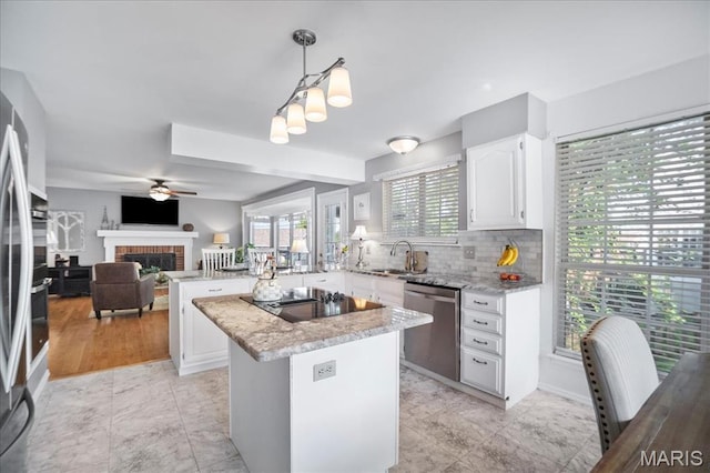 300 Wildberry Ln, Saint Charles, MO 63304 - kitchen with stainless steel appliances, a peninsula, white cabinets, open floor plan, and light stone countertops