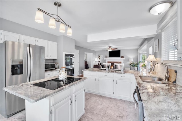300 Wildberry Ln, Saint Charles, MO 63304 - kitchen with appliances with stainless steel finishes, a fireplace, a peninsula, a ceiling fan, and light stone counters