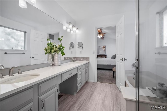300 Wildberry Ln, Saint Charles, MO 63304 - bathroom with double vanity, a ceiling fan, ensuite bathroom, a stall shower, and wood finished floors