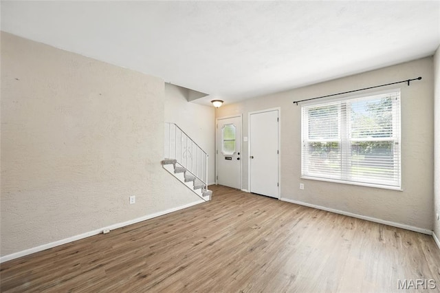 10161 Squire Meadows Drive E, Saint Louis, MO 63123 - entryway featuring wood finished floors, stairway, and a textured wall