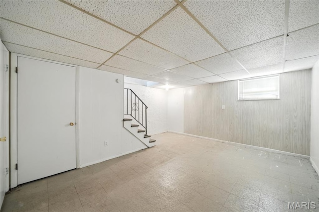 10161 Squire Meadows Drive E, Saint Louis, MO 63123 - basement featuring stairway, a drop ceiling, wood walls, and tile patterned floors