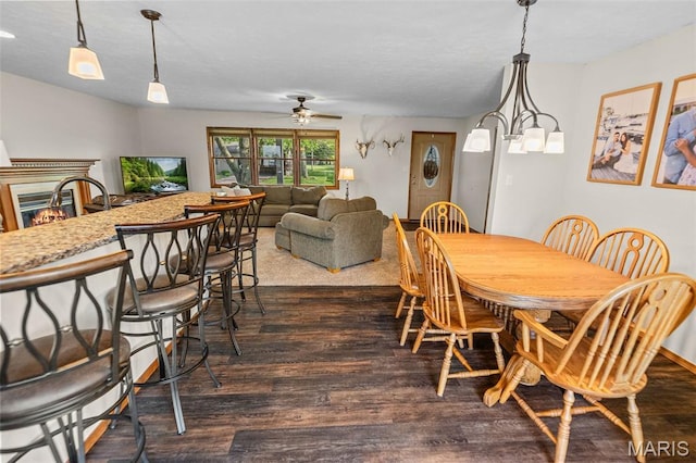 511 E Wilson St, Beckemeyer, IL 62219 - dining space featuring dark wood-style flooring, ceiling fan, and a warm lit fireplace