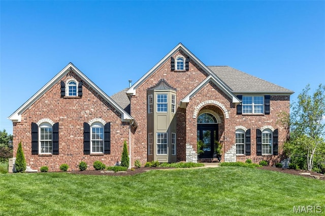 5316 Enchanted Ct, Weldon Spring, MO 63304 - view of front of house with brick siding, a front yard, and a shingled roof