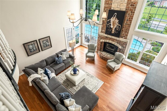 5316 Enchanted Ct, Weldon Spring, MO 63304 - living room with a high ceiling, wood finished floors, a brick fireplace, and a chandelier