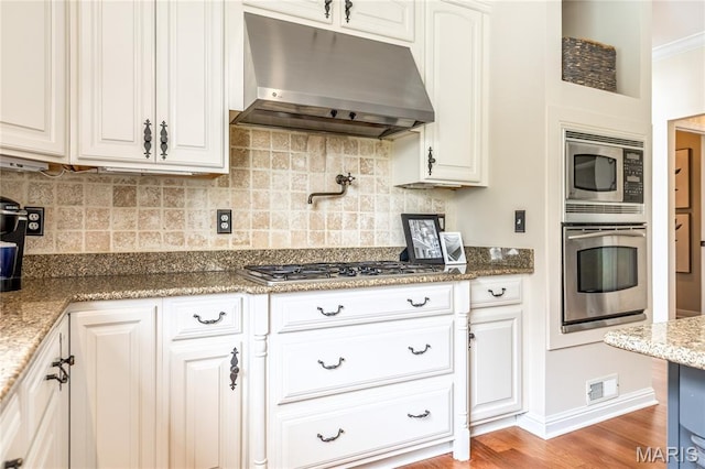 5316 Enchanted Ct, Weldon Spring, MO 63304 - kitchen with stainless steel appliances, under cabinet range hood, and decorative backsplash