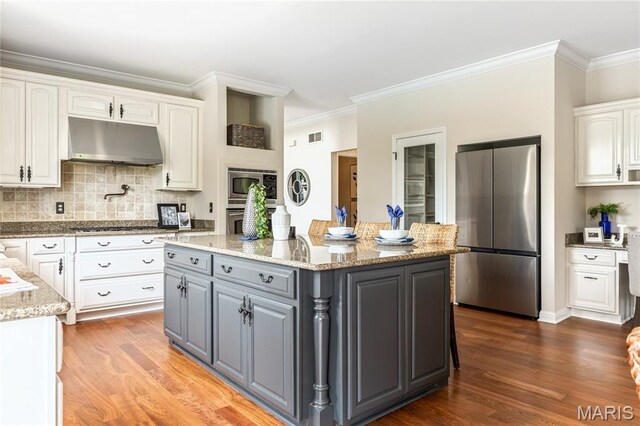 5316 Enchanted Ct, Weldon Spring, MO 63304 - kitchen with stainless steel appliances, under cabinet range hood, gray cabinetry, white cabinetry, and crown molding