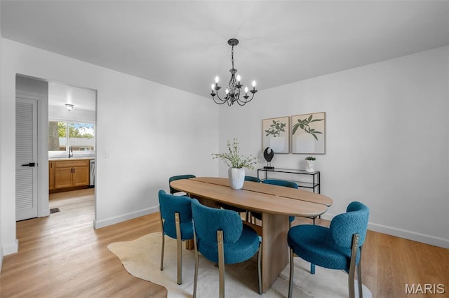 2736 Ashrock Dr, Saint Louis, MO 63129 - dining area with a chandelier, baseboards, and light wood-style flooring