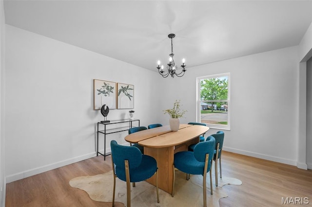 2736 Ashrock Dr, Saint Louis, MO 63129 - dining area featuring a chandelier, light wood-type flooring, and baseboards