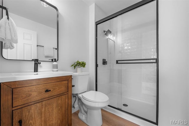 2736 Ashrock Dr, Saint Louis, MO 63129 - full bathroom featuring toilet, a stall shower, vanity, and wood finished floors