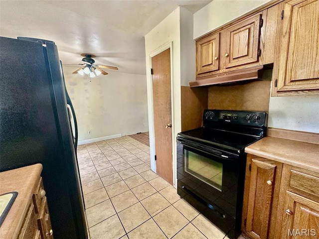 860 Chouteau Ave, Godfrey, IL 62035 - kitchen featuring black appliances, ceiling fan, light tile patterned floors, under cabinet range hood, and light countertops