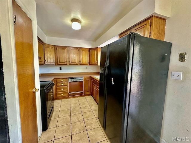 860 Chouteau Ave, Godfrey, IL 62035 - kitchen with black appliances, brown cabinetry, light countertops, and light tile patterned flooring