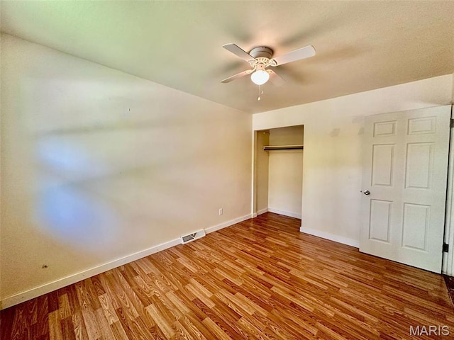 860 Chouteau Ave, Godfrey, IL 62035 - unfurnished bedroom with wood finished floors, baseboards, a closet, and a ceiling fan