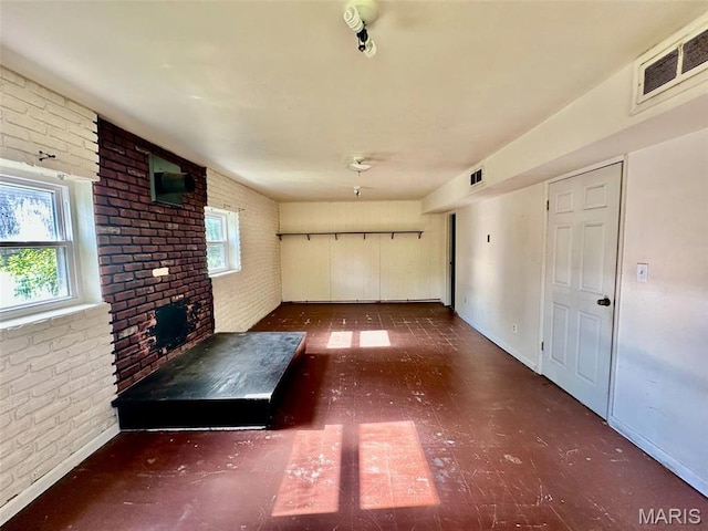 860 Chouteau Ave, Godfrey, IL 62035 - unfurnished living room with brick wall, tile patterned floors, baseboards, and a fireplace