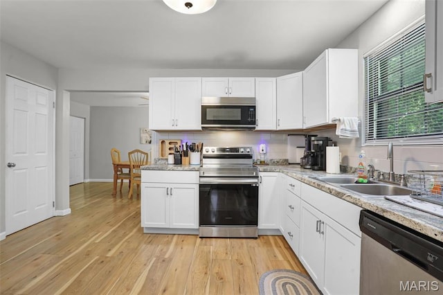 28 French Quarter, Belleville, IL 62223 - kitchen with stainless steel appliances, white cabinetry, and light wood finished floors