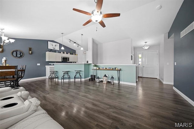 living room with vaulted ceiling, ceiling fan, baseboards, a chandelier, and dark wood finished floors