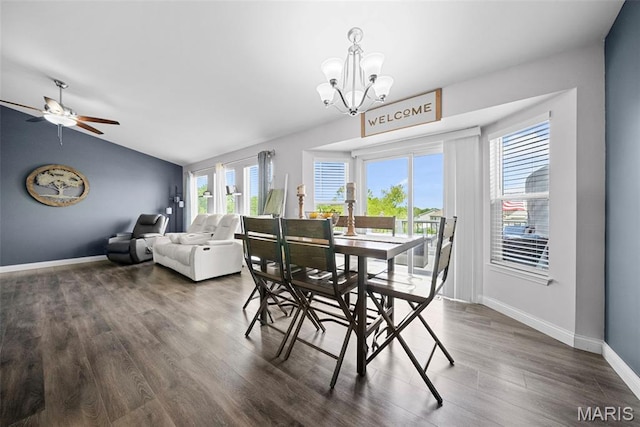dining space featuring healthy amount of natural light, a chandelier, lofted ceiling, wood finished floors, and baseboards