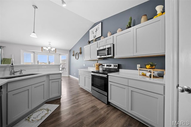 kitchen with stainless steel appliances, a sink, a chandelier, lofted ceiling, and light countertops