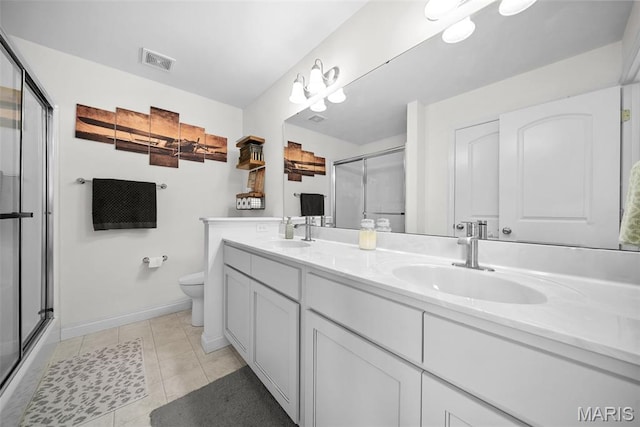 full bath with a stall shower, toilet, double vanity, baseboards, and tile patterned flooring