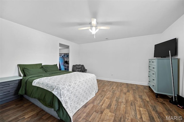 bedroom featuring wood finished floors, baseboards, a ceiling fan, and a closet
