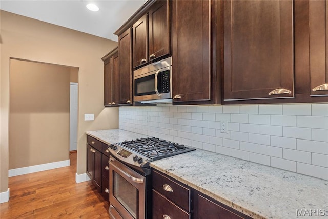1419 Crimson King Way, Troy, IL 62294 - kitchen featuring stainless steel appliances, wood finished floors, baseboards, dark brown cabinetry, and light stone countertops