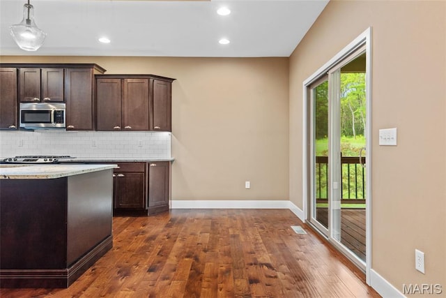 1419 Crimson King Way, Troy, IL 62294 - kitchen featuring stainless steel microwave, dark wood-type flooring, backsplash, dark brown cabinetry, and baseboards