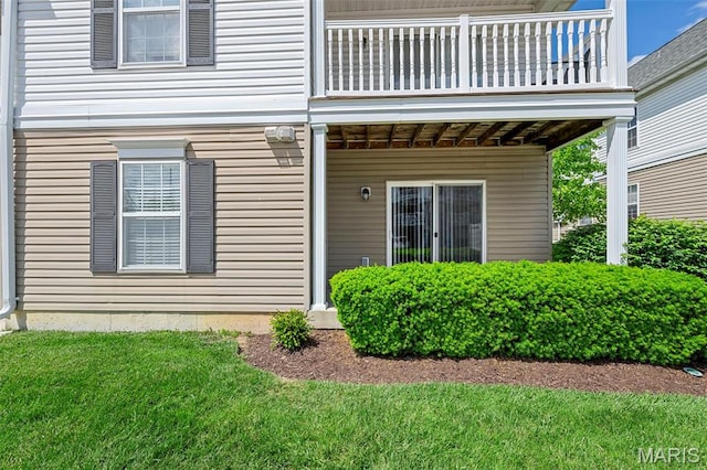 entrance to property with a balcony and a lawn