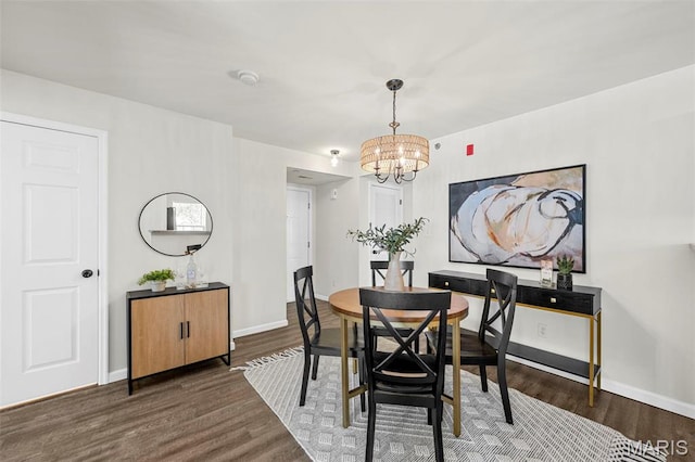 dining room with a chandelier, dark wood-style floors, and baseboards