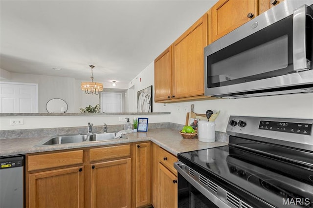 kitchen with stainless steel appliances, a sink, a chandelier, and light countertops