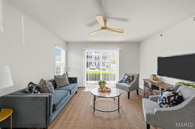 living room featuring a ceiling fan, wood finished floors, and baseboards