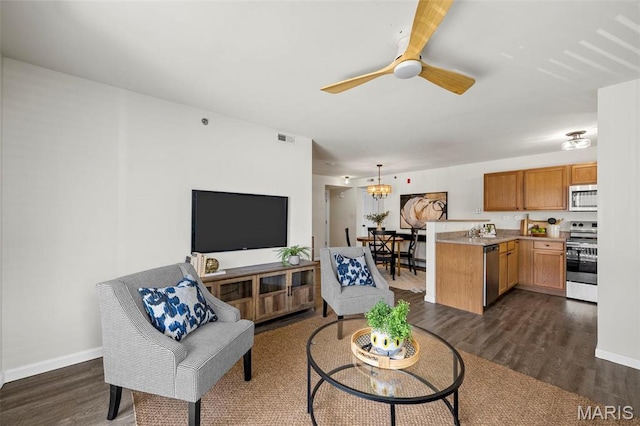 living room featuring dark wood finished floors, ceiling fan, and baseboards