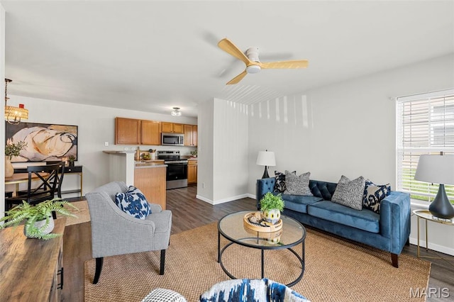 living room featuring dark wood-type flooring, a ceiling fan, and baseboards