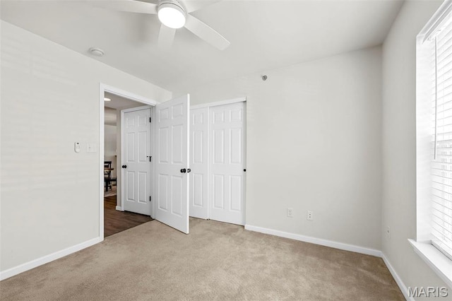 unfurnished bedroom with carpet floors, baseboards, a closet, and a ceiling fan