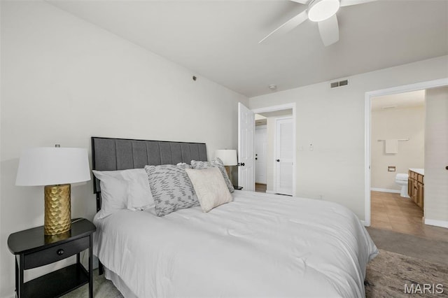 bedroom featuring baseboards, a ceiling fan, and ensuite bathroom