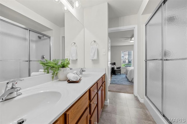 full bath with tile patterned floors, a shower stall, and double vanity