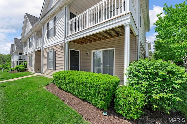 entrance to property with a balcony and a lawn