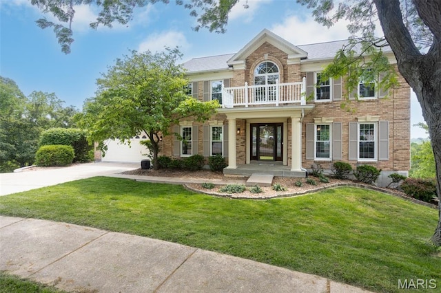 712 Carman Oaks Ct, Manchester, MO 63021 - colonial inspired home featuring a balcony, driveway, brick siding, and a front lawn
