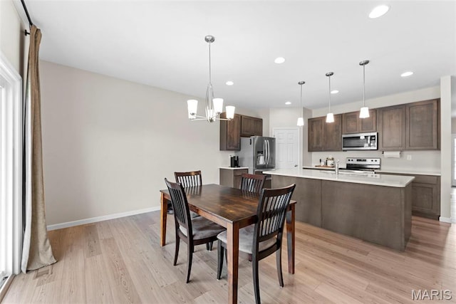 dining space featuring light wood-type flooring, recessed lighting, a chandelier, and baseboards