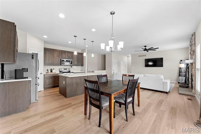 dining room with light wood-style floors, a chandelier, a ceiling fan, and recessed lighting