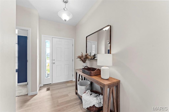 foyer featuring light wood finished floors and baseboards