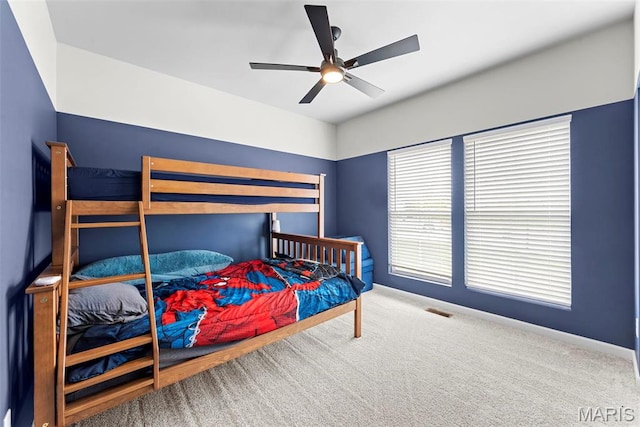 carpeted bedroom with a ceiling fan and baseboards