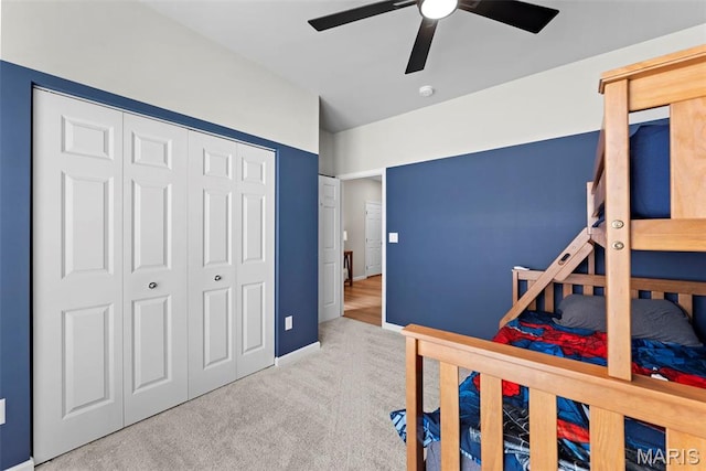 carpeted bedroom featuring a closet, a ceiling fan, and baseboards