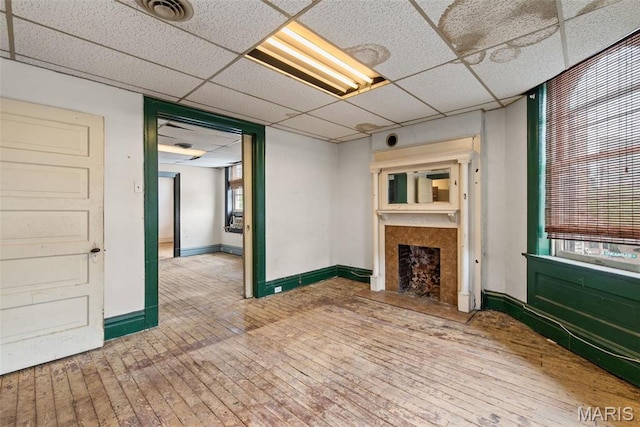 3456 Miami St, Saint Louis, MO 63118 - unfurnished living room with a paneled ceiling, a fireplace, baseboards, and hardwood / wood-style floors
