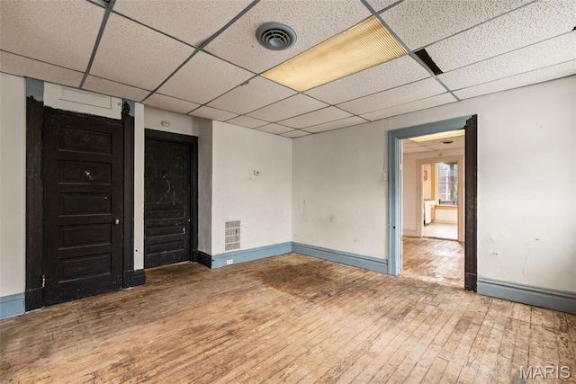 3456 Miami St, Saint Louis, MO 63118 - unfurnished room featuring hardwood / wood-style flooring, a paneled ceiling, and baseboards