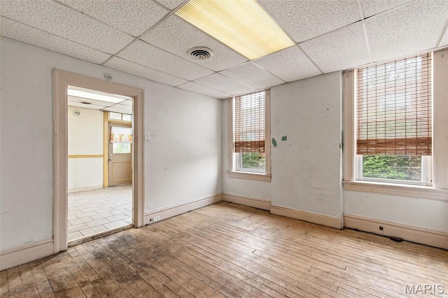 3456 Miami St, Saint Louis, MO 63118 - unfurnished room with wood-type flooring, a drop ceiling, and baseboards